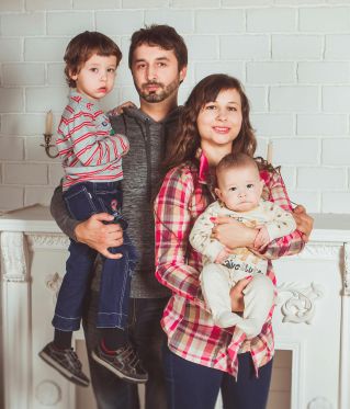 A joyful family posing together in a cozy living room, embodying love and togetherness.